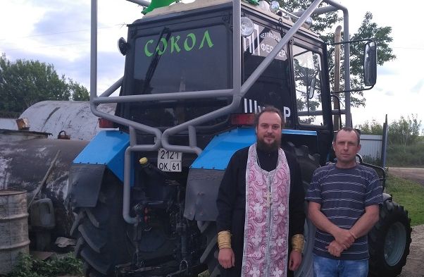 Священник благословил участника тракторных гонок